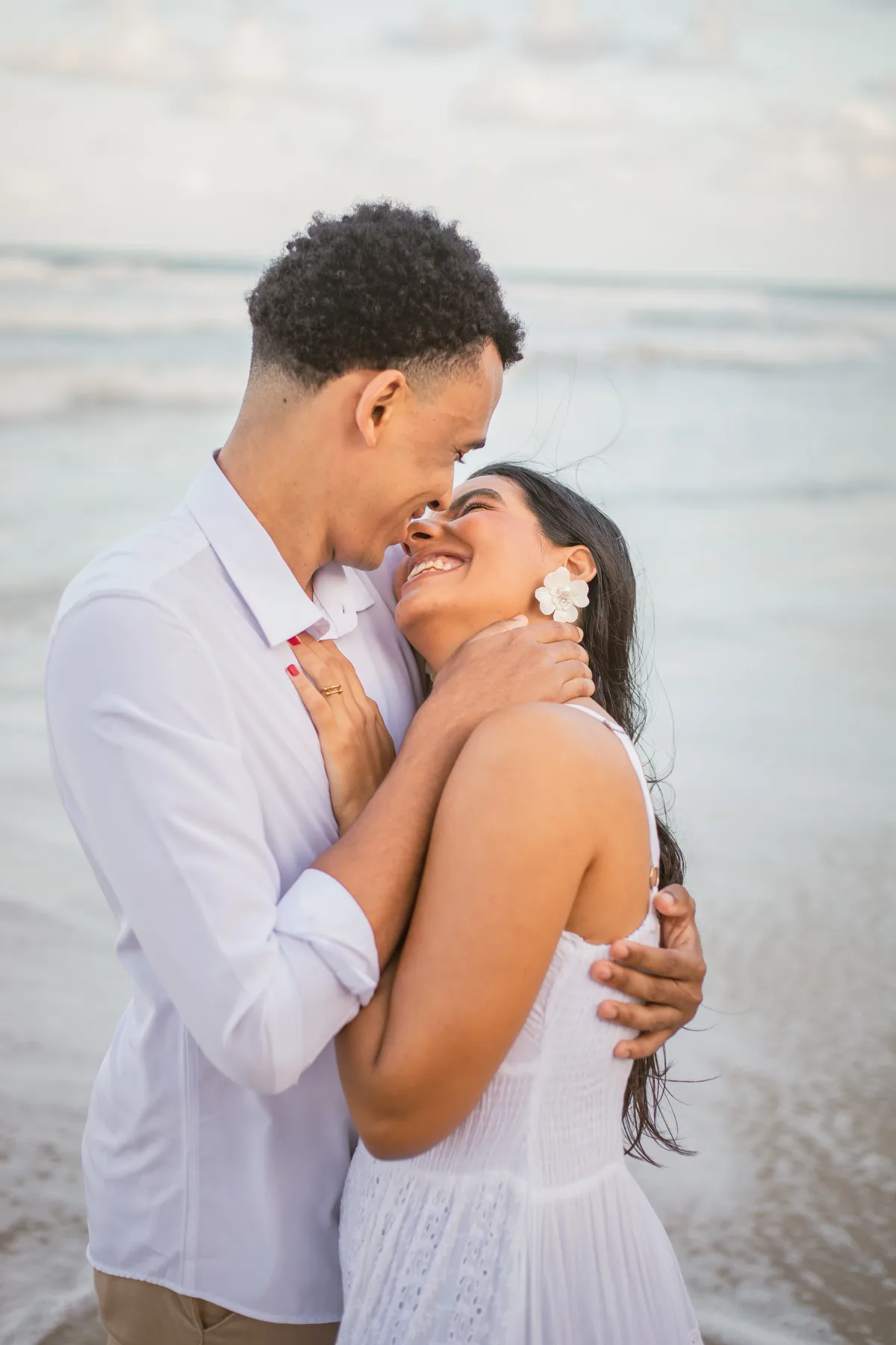 Retrato do casal testa com testa na praia, sorrindo